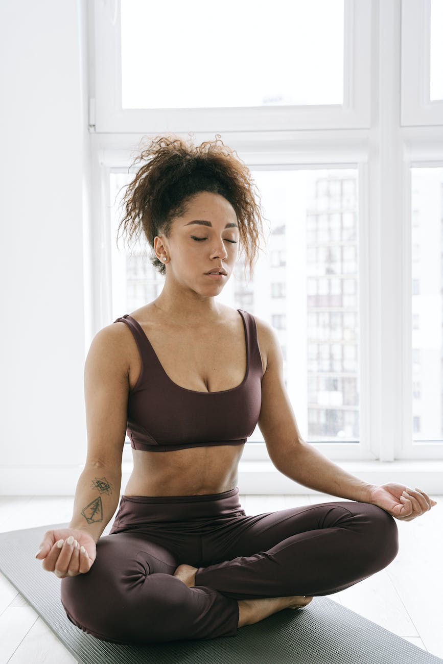 beautiful woman practicing meditation on yoga mat